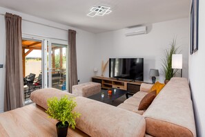 Ein modernes Wohnzimmer mit einer Couch, einem Fernseher und einem Couchtisch.
