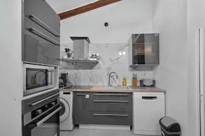A compact kitchen with a microwave, oven, sink, and dishwasher. - ☀️ In the heart of Rue Meynadier & Palais (Cannes)