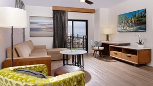 Une chambre d’hôtel moderne équipée d’un canapé, d’un fauteuil, d’une table à manger et d’un ventilateur de plafond.