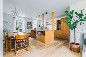 A modern kitchen with wooden cabinets, a central island, and a potted plant. - Terraced house in Komponistkvarteret, Østerbro (København)