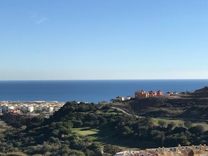 A coastal town with buildings on a hillside overlooking the sea. - Duquesa Village El Hacho (Manilva)