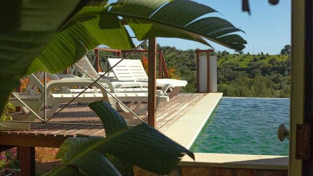 Una piscina infinita con vistas a un paisaje verde.