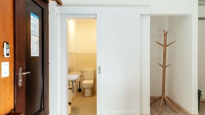 Ein Badezimmer mit Toilette, Waschbecken und Kleiderhaken.