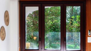 Ein Holzrahmenfenster mit Blick auf einen Garten.