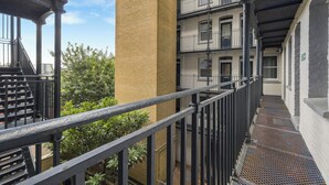 Ein mehrstöckiges Gebäude mit einer zentralen Backstein-Säule, Balkonen und einer Treppe.