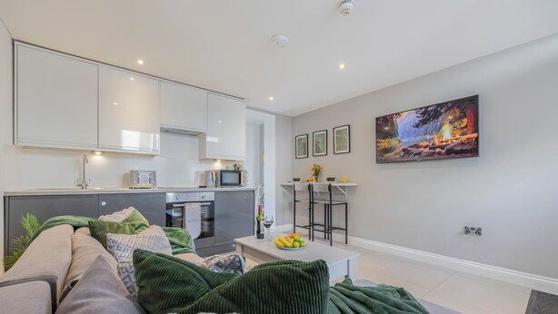 Ein modernes Wohnzimmer mit Sofa, Couchtisch und einem Bild an der Wand.