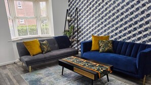A living room with two sofas, a coffee table, and a patterned rug. - Comfortable 3BR Family Home | Free Parking Included (Chester)