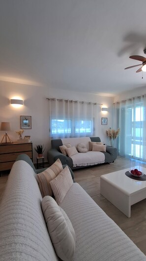 A modern living room with a sofa, a coffee table, and a lamp. - The Yellow Cube - Mediterranean Living (Kožino)