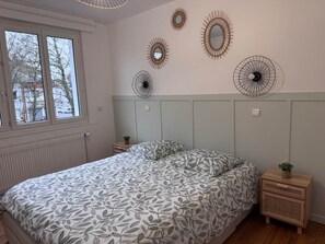 A bedroom with a bed, bedside tables, and wall decorations.