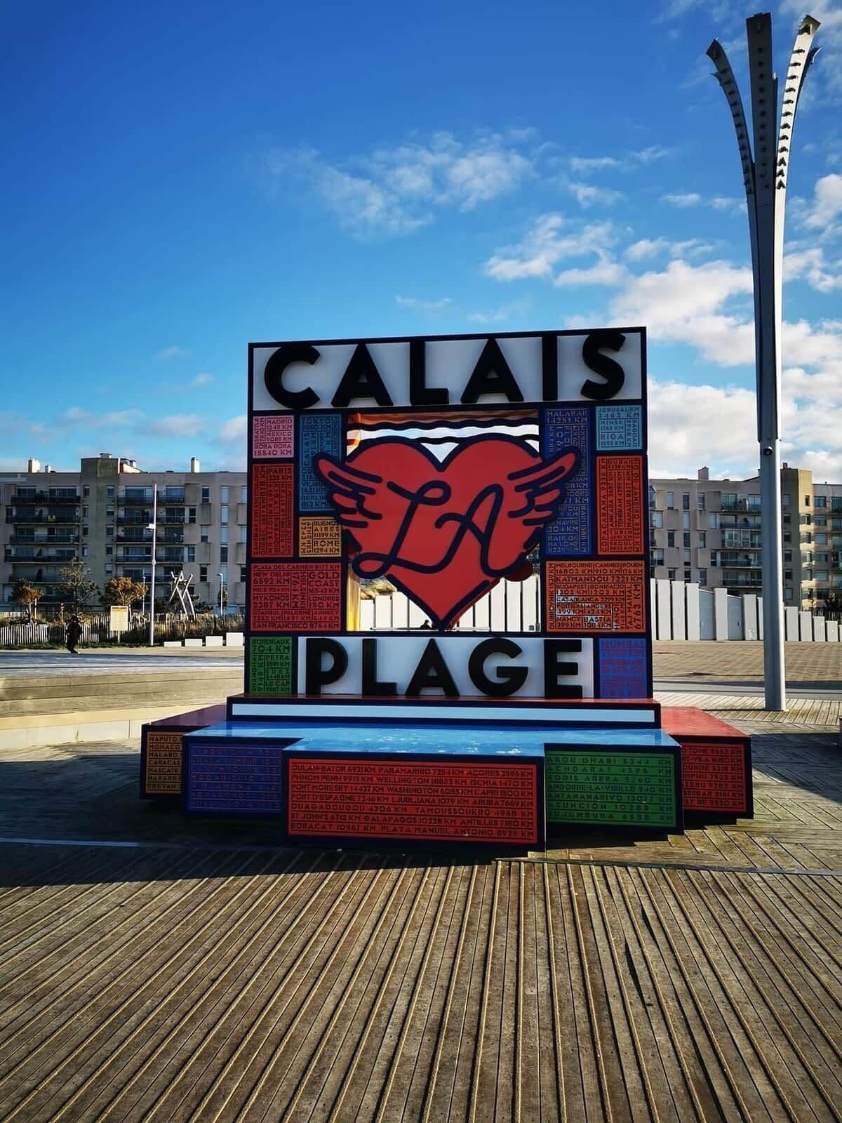 Ein Promenadenweg mit einem Schild, das ein Herz und die Worte 'CALAIS PLAGE' zeigt.