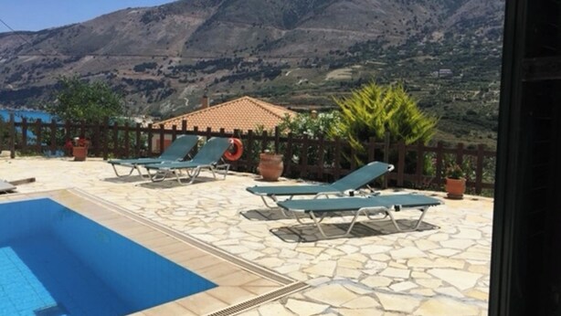 Un espace piscine avec des chaises longues et une vue sur les montagnes.