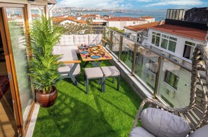 A balcony with a dining table, chairs, and a potted plant. - Bosphorus View Apt With 2 Terraces At Monnas Suite (Istanbul)