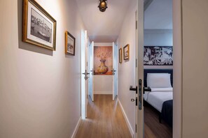 A hallway with framed pictures, a vase, and a bed in the room. - Bosphorus View Apt With 2 Terraces At Monnas Suite (Istanbul)