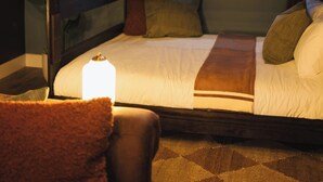 Un lit superposé avec une fenêtre au-dessus, des rideaux et une lampe de chevet.
