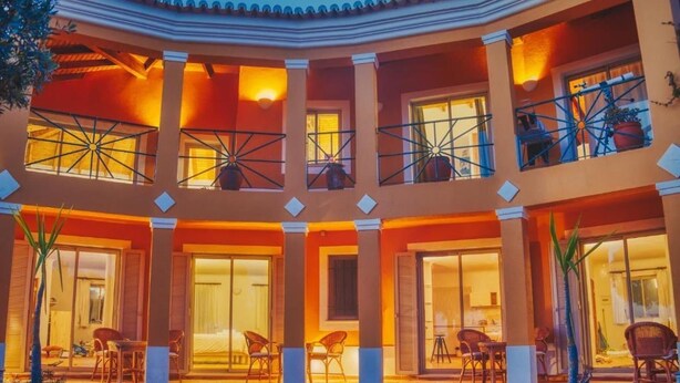 Un hotel de varios niveles con balcones, ventanas amplias y zonas de estar al aire libre.