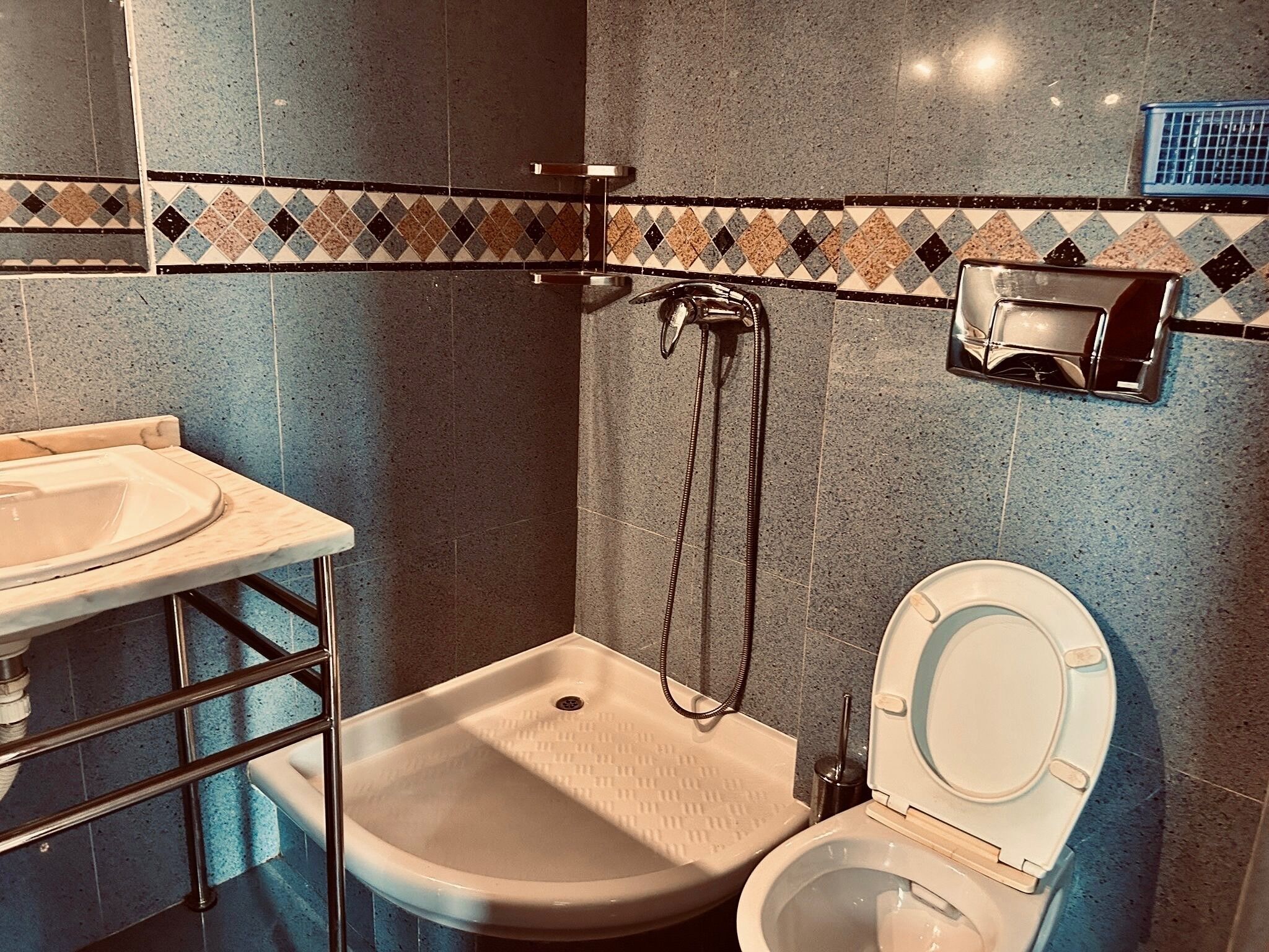 A bathroom with a sink, toilet, and shower.