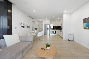 Ein modernes Wohnzimmer mit Sofa, Couchtisch und Essbereich.