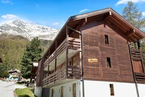 A wooden building with a balcony, a sign reading 'La Cassanoia,' and a mountainous backdrop. - Convenient studio with view in the center of the resort (Anniviers)