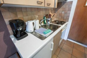 A compact kitchen with a coffee maker, kettle, sink, and various utensils. - Convenient studio with view in the center of the resort (Anniviers)