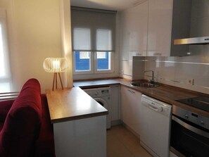 Eine kompakte Küche mit Waschmaschine, Geschirrspüler und Backofen.