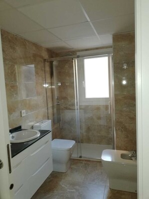 Un bagno con doccia, servizi igienici e lavandino.