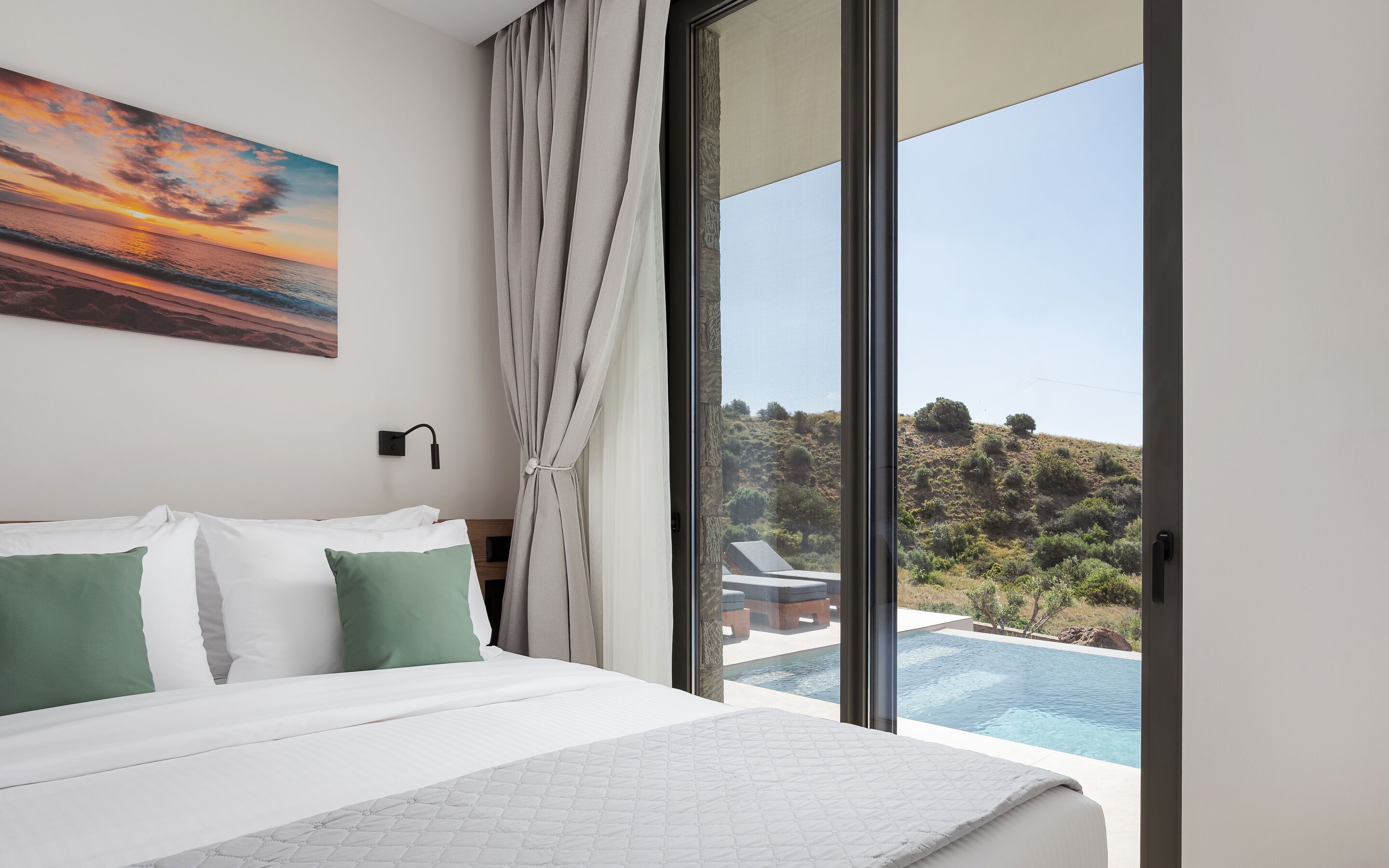 Een slaapkamer met een groot bed, een schilderij, een raam met gordijnen en uitzicht op een zwembad en het landschap.