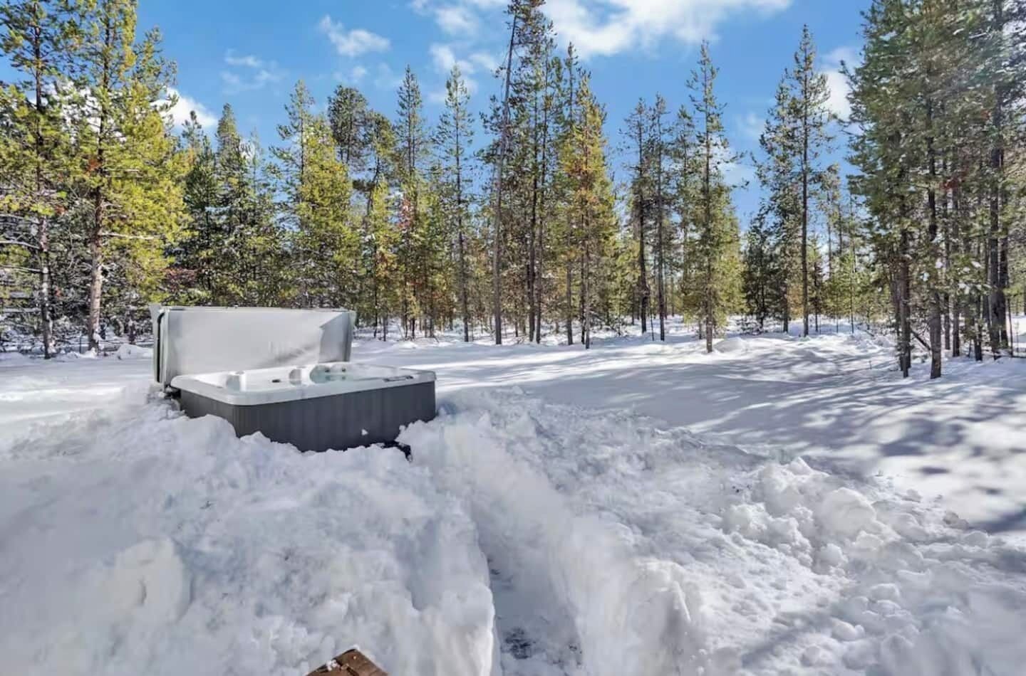 Schneeverdeckte Landschaft mit einem Whirlpool, der teilweise im Schnee versinkt.
