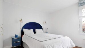 Ein Schlafzimmer mit einem Bett, Nachttischen und einem Fenster.