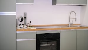 A modern kitchen with a built-in oven, a stainless steel sink, and a range hood. - Cozy house 2 minutes from Reggio Calabria Cathedral and Via Marina (Reggio Calabria)
