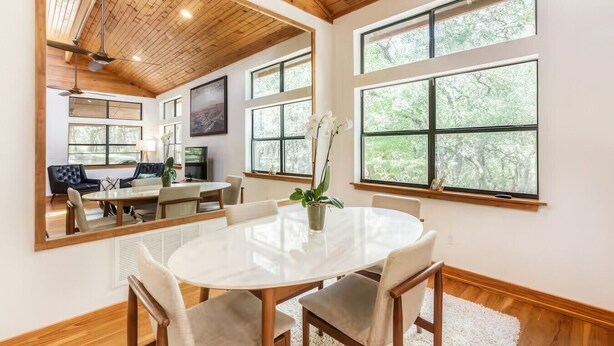 A dining area with a round table, chairs, and a vase with flowers. - Olinca Ranch - Private Texas Oasis (Driftwood)