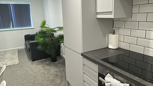 A modern kitchen with grey cabinets, a black countertop, and a stainless steel oven. - Peaceful 2BR Stay with Fast Reliable Wi-Fi (Kingston upon Hull)