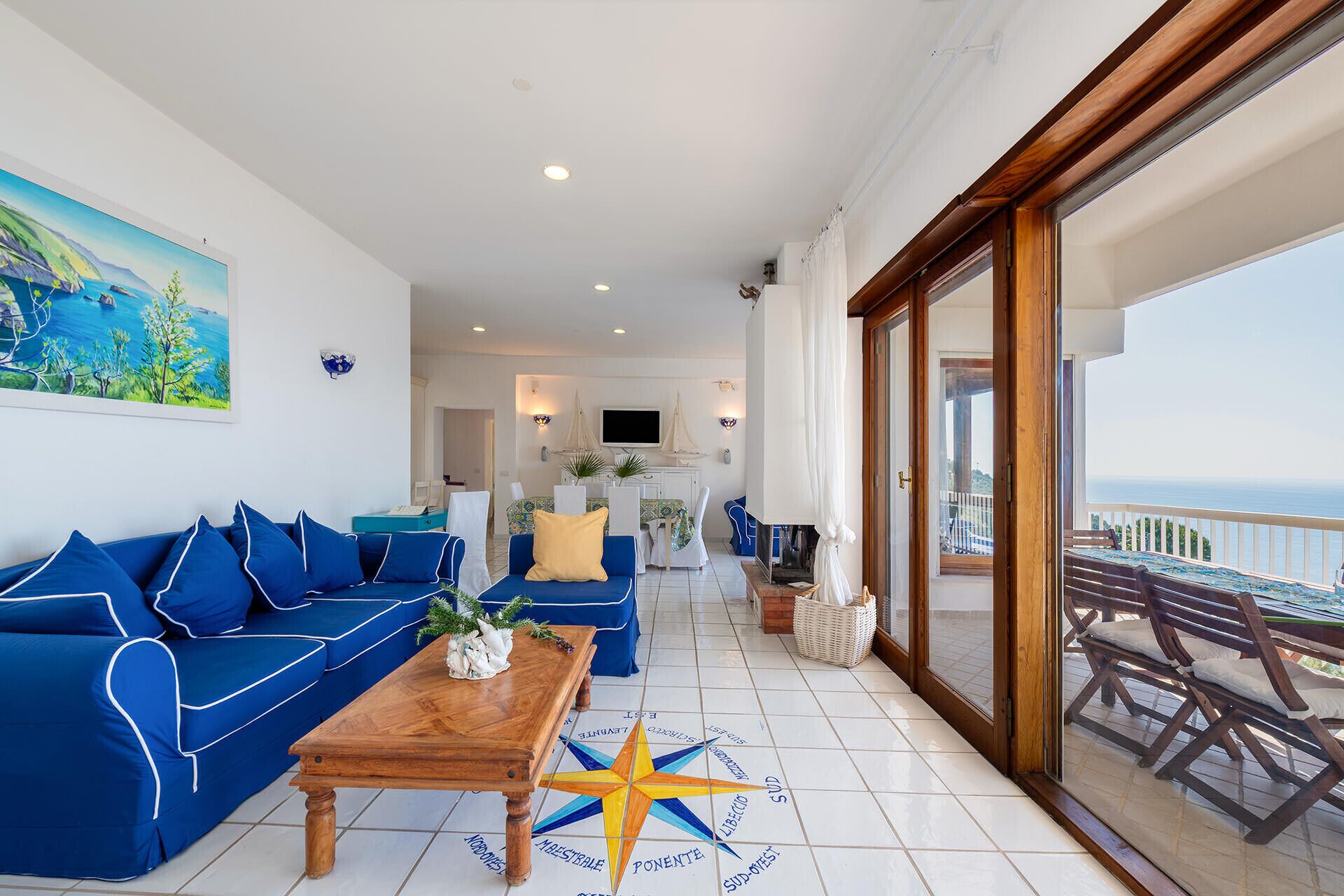 Una habitación con un sofá azul, una mesa de centro de madera y una alfombra con estampado de estrella de mar.