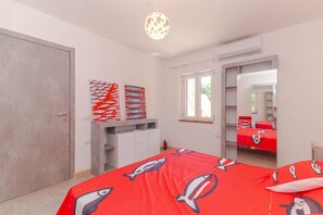 A bedroom with a bed, a wardrobe, a desk, and a window. - Apartment 'Villino San Teodoro' with Private Terrace, Garden and Air Conditioning (San Teodoro)