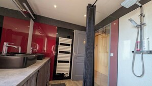 Ein modernes Badezimmer mit Dusche, Waschbecken und Handtuchhalter.