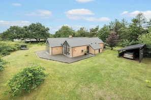 A modern house with a large deck, a garage, and a covered outdoor area. - Holiday home on a large natural lot by Hjarbæk (Skals)