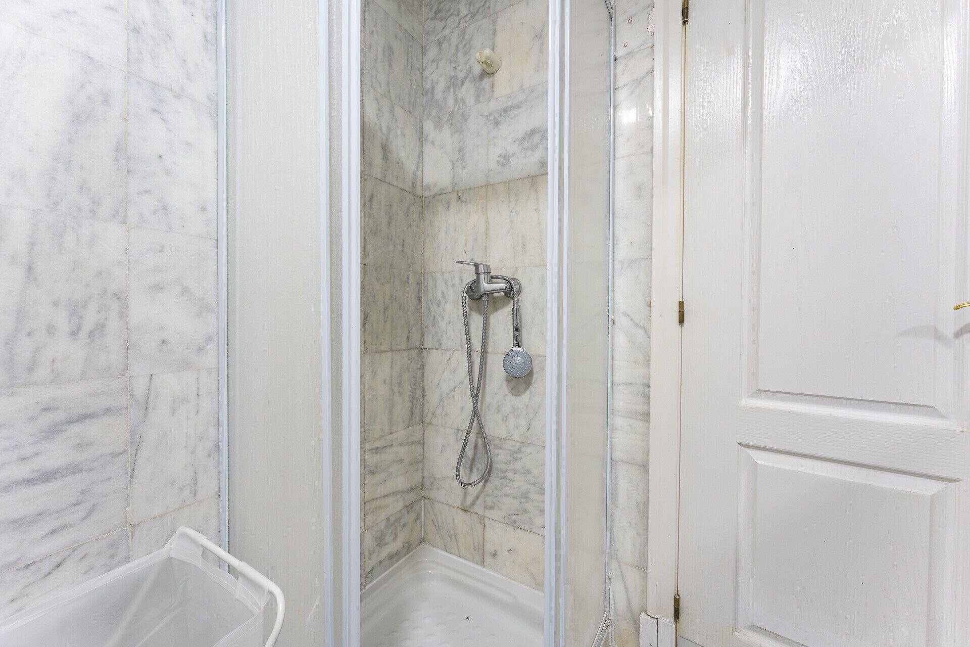 Een badkamer met een douche, een bad en een toilet.
