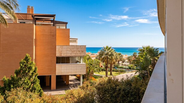 Un edificio moderno con balcón y vista al mar.