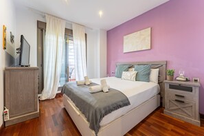 Een slaapkamer met een bed, een bureau, een stoel en een raam met gordijnen.