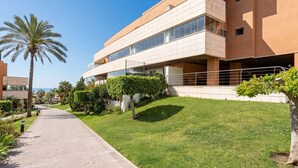 Un edificio moderno con techo plano, ventanas amplias y un camino pavimentado.