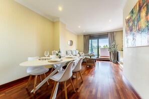 Een eethoek met een lange tafel, stoelen en een bank.