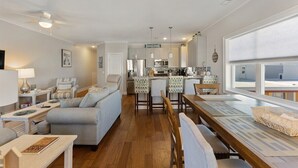 Un soggiorno moderno con un divano, un tavolo da pranzo e un'area cucina sullo sfondo.