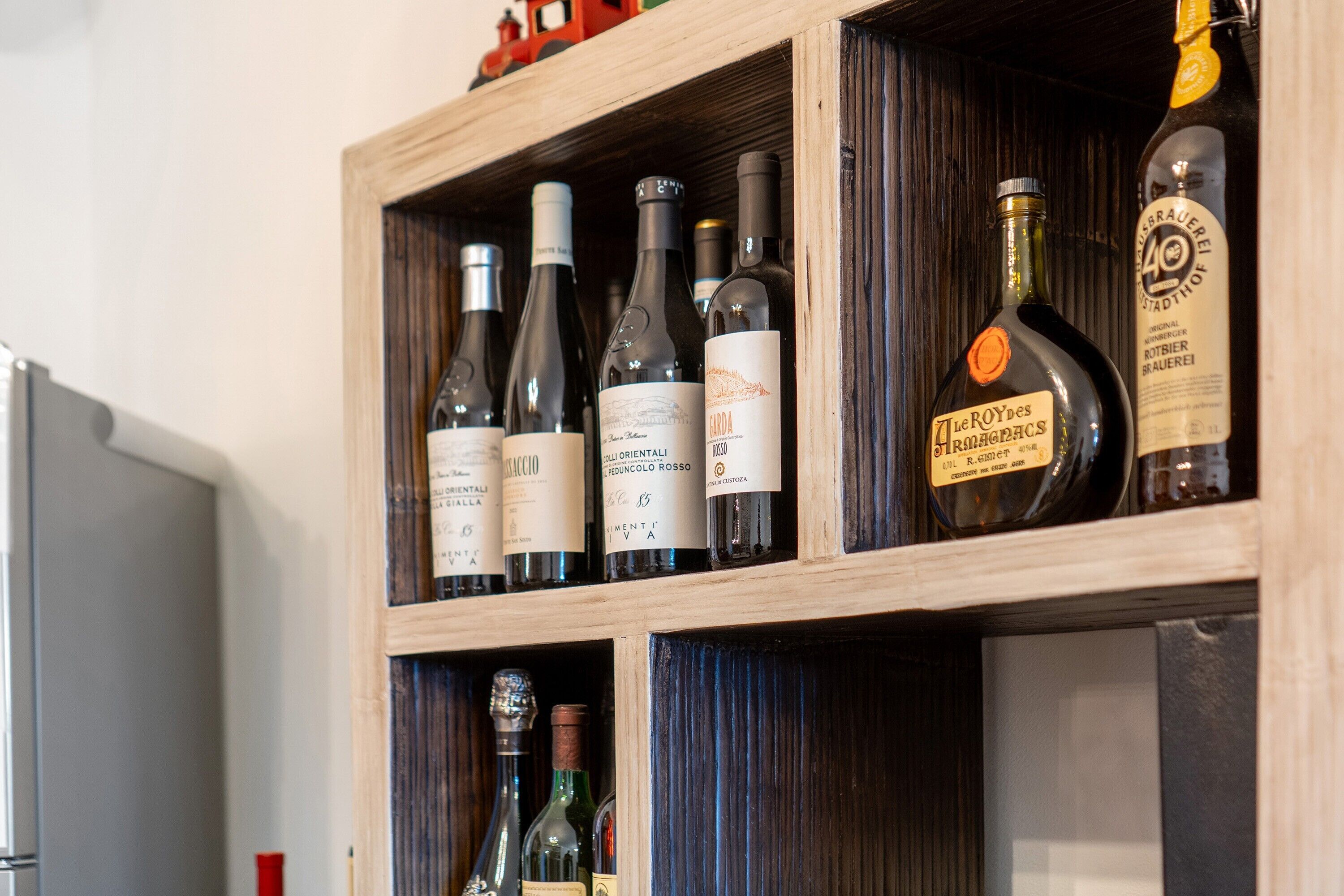 A wooden wine rack with bottles of wine.