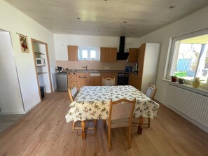A compact kitchen with wooden cabinets, a built-in microwave, and a window with a view of the outdoors.