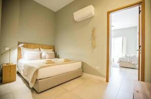 Ein Schlafzimmer mit Bett, Nachttischlampe und Klimaanlage.