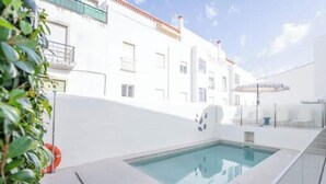 Un edificio moderno con piscina, balconi e cielo sereno.