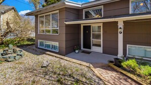 A two-story house with a front porch, a garage, and a small garden area. - West End 4BR  Stay Patio BBQ Firepit  WiFi Parking (St. John's)