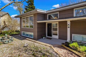 A two-story house with a front porch, a garage, and a small garden area.