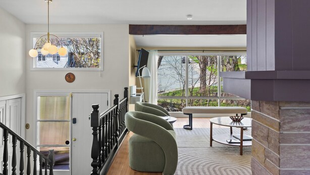 A modern interior with a staircase, a dining area with a bench, and a large window with a view. - West End 4BR  Stay Patio BBQ Firepit  WiFi Parking (St. John's)