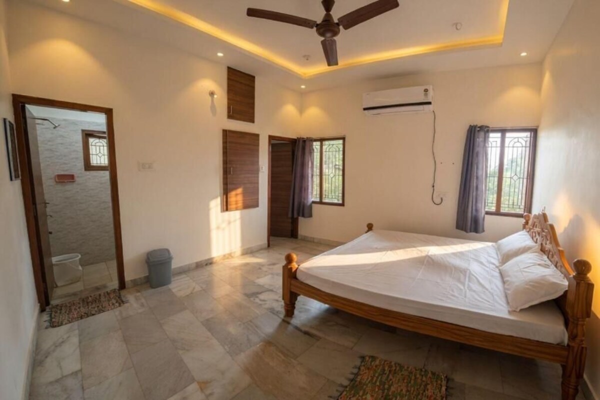 A bedroom with a wooden bed, an air conditioning unit, and a ceiling fan.