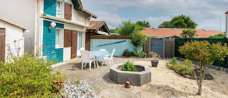 A house with a patio, a fire pit, and a small garden.